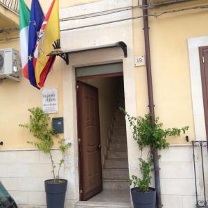 una puerta a un edificio con bandera en La Perla Di Noto, en Noto