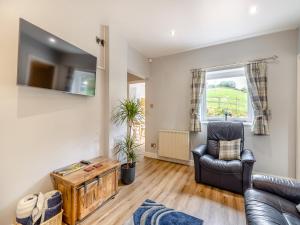 a living room with a couch and a chair at Woodlands Barn in Chinley