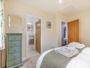 um quarto com uma cómoda verde e uma cama em Woodlands Barn em Chinley