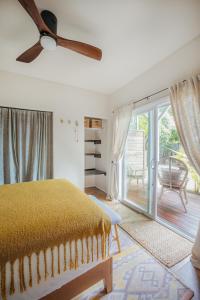 - une chambre avec un lit et une porte coulissante en verre dans l'établissement The Ohia at The Koi House, à Kailua-Kona