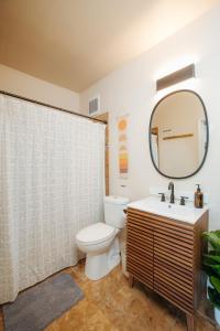 a bathroom with a toilet and a sink and a mirror at The Ohia at The Koi House in Kailua-Kona