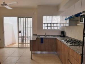 una grande cucina con lavandino e piano cottura di Casa de 3 habitaciones TODAS con baño propio, 3 y medio baños en toal, alberca, cupo hasta 12 personas a Playa del Carmen