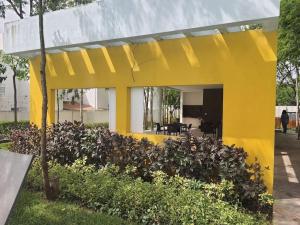 una casa gialla con un mucchio di piante di Casa de 3 habitaciones TODAS con baño propio, 3 y medio baños en toal, alberca, cupo hasta 12 personas a Playa del Carmen