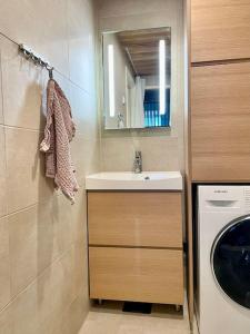 a bathroom with a sink and a washing machine at Marina Sunset Resort A2 in Kalajoki