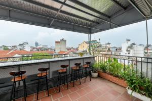 a balcony with bar stools and a view of the city at Golden Sun Hotel in Hanoi