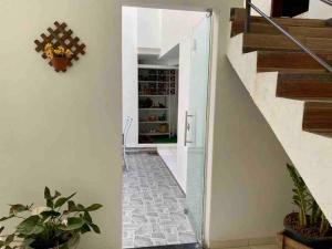 a hallway of a home with a staircase and a floor with plants at Apartamento encantador 3 in Montes Claros