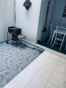 a room with a table and a chair on a tiled floor at Apartamento encantador 3 in Montes Claros