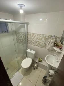 a bathroom with a shower and a toilet and a sink at Apartamento encantador 3 in Montes Claros