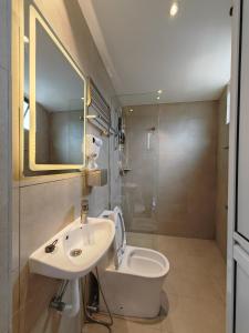 a bathroom with a sink and a toilet and a mirror at V Boutique Hotel Seremban in Seremban