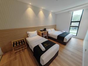 a hotel room with two beds and a window at V Boutique Hotel Seremban in Seremban