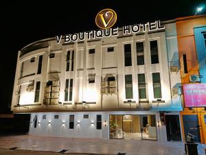 a large white building with a hotel sign on it at V Boutique Hotel Seremban in Seremban