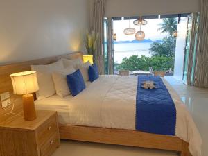 um quarto com uma cama grande e almofadas azuis em Purana Resort Koh Yao Noi - SHA Extra plus em Ko Yao Noi