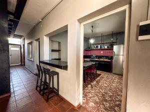 eine Küche mit einer Theke und ein paar Stühlen darin in der Unterkunft Casa Céntrica para 7 personas Estacionamiento Gratuito in Mendoza