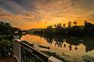 a sunset over a river with a boat on it at Casa Marina Bed and Breakfast in Pagsanjan