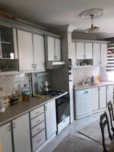Una cocina con gabinetes blancos y un horno de estufa. en Homestay Guest House Dormitory Sleeping Rooms - BE MY GUEST, en Antalya 26 fotos más