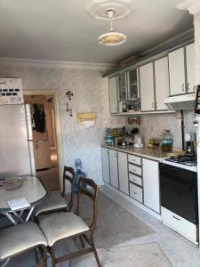 cocina con armarios blancos, mesa y sillas en Homestay Guest House Dormitory Sleeping Rooms - BE MY GUEST, en Antalya
