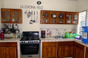 a kitchen with wooden cabinets and a stove top oven at Matagalpa Tours Guest House in Matagalpa +27 photos
