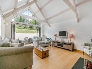 a living room with two couches and a tv at Myrtle Cottage in Saint Just in Roseland