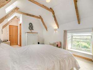 a bedroom with a white bed and a window at Myrtle Cottage in Saint Just in Roseland