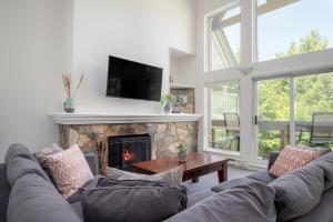 un soggiorno con divano e camino di Gorgeous Chalet with Fairway Views by Harmony Whistler a Whistler
