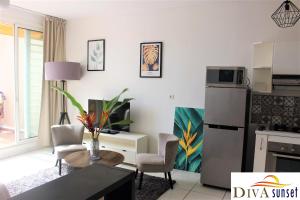 a kitchen and a living room with a table and chairs at Tahiti Diva Sunset studio in Papeete