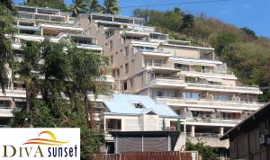an apartment building with a sign in front of it at Tahiti Diva Sunset studio in Papeete