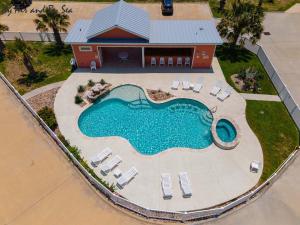 an overhead view of a swimming pool with chairs and a house at By Air & By Sea in Port Aransas