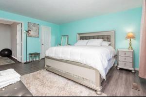 a bedroom with a large bed with a blue wall at Wood Fire-pit! BBQ Grill! Cal King bed! Pets OK! Washer & Dryer! Wifi! in Charlotte