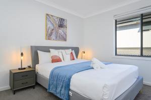 two beds in a bedroom with two windows at The Pond sweet 4 br home by Coles with garage&WiFi in Schofields