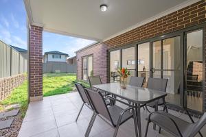 a dining room with a table and chairs on a patio at The Pond sweet 4 br home by Coles with garage&WiFi in Schofields