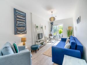 a living room with blue couches and a tv at Seabreeze in Kinghorn