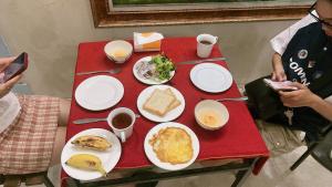 una mesa roja con platos de comida. en Cat Ba Mystery Homestay, en Cat Ba