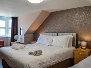 a bedroom with a large bed with towels on it at Montys in Castle Douglas