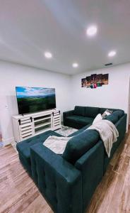 ein Wohnzimmer mit einem Sofa und einem TV in der Unterkunft Entire 3/1 house near Wynwood! in Miami