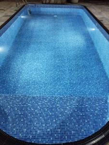 an empty swimming pool with blue tiles on the floor at Pousada Acolhedora in Ribeirão Preto