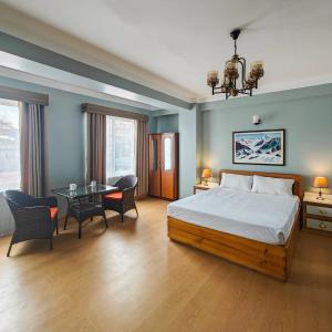 1 dormitorio con 1 cama, mesa y sillas en Boudha Apart Hotel en Katmandú