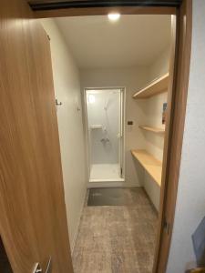 ein Bad mit einer Dusche und einem begehbaren Kleiderschrank in der Unterkunft The Toya in Tōya-See
