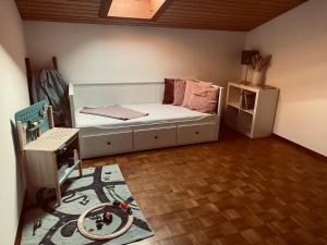 a bedroom with a white bed and a table and a rug at Ferienwohnung Bergliebe in Staudach-Egerndach