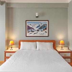 una camera da letto con un letto bianco con due comodini di Boudha Apart Hotel a Kathmandu