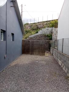 um beco vazio ao lado de um edifício com uma cerca em bungalow les cases près de la Mare à joncs em Cilaos