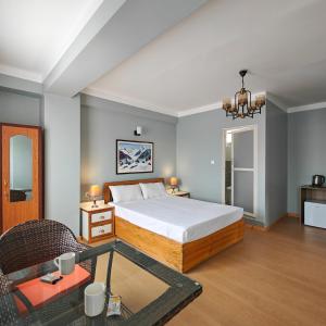 una camera da letto con un letto, un tavolo e una sedia di Boudha Apart Hotel a Kathmandu