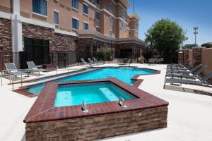 Courtyard by Marriott Lubbock Downtown/University Area في لوبوك: مسبح وكراسي ومبنى