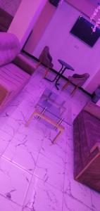 a room with purple lighting and a table and chairs at Hotel La coline in Beni Mellal