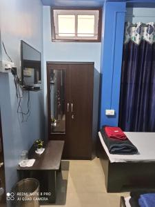 Habitación con cama y TV. en Maity lodge en Gangtok
