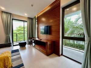 ein Schlafzimmer mit einem TV und einem großen Fenster in der Unterkunft West Phu Quoc 3BR beach villa private swimming pool in Phu Quoc