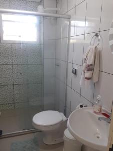 a white bathroom with a toilet and a sink at UNIJUI in Ijuí