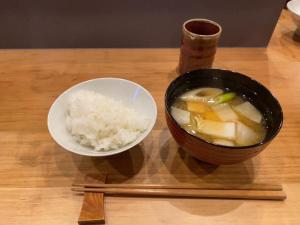 eine Schüssel Suppe und eine Schale Reis auf dem Tisch in der Unterkunft Mitsubikiya in Matsumoto