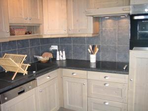 a kitchen with white cabinets and a black counter top at Appartement cosy aux Gets avec balcon, proche pistes, 2 chambres, parking privé, Wi-Fi - FR-1-671-20 in Les Gets