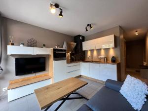eine Küche mit weißen Schränken, einem Sofa und einem Tisch in der Unterkunft Studio Les Gets, 1 pièce, 4 personnes - FR-1-623-194 in Les Gets