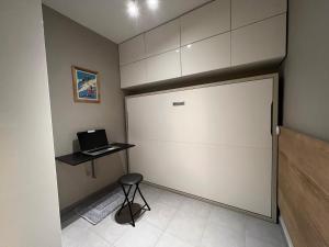 Zimmer mit einer Tür, einem Hocker und einem Laptop in der Unterkunft Studio Les Gets, 1 pièce, 4 personnes - FR-1-623-194 in Les Gets